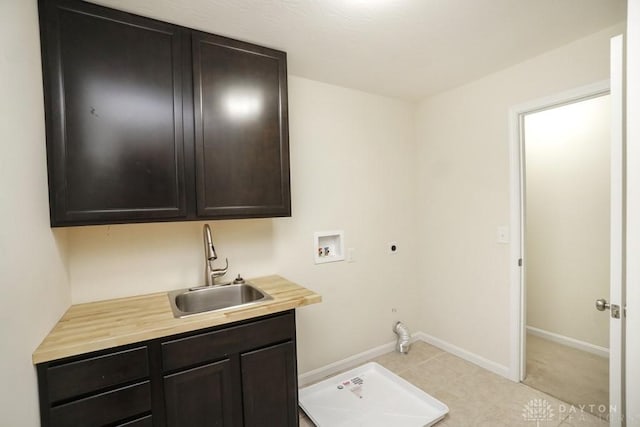 washroom with washer hookup, cabinet space, hookup for an electric dryer, a sink, and baseboards