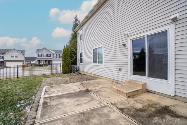 exterior space featuring central AC unit, fence, and a residential view