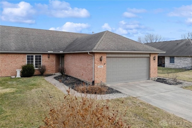 ranch-style home with a garage, a shingled roof, concrete driveway, a front lawn, and brick siding