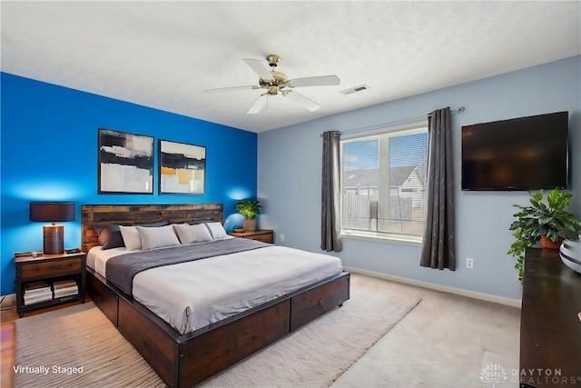 carpeted bedroom featuring a ceiling fan, visible vents, and baseboards