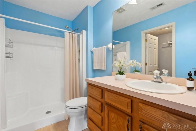 full bath with toilet, a shower stall, visible vents, and vanity