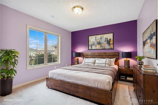 bedroom featuring visible vents, light colored carpet, and baseboards