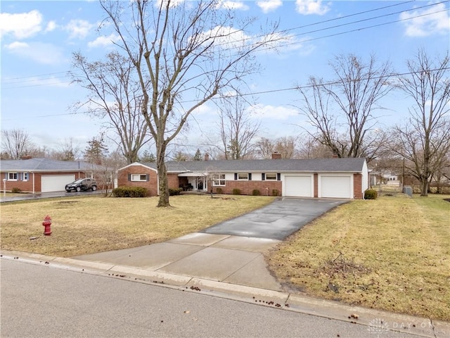 ranch-style home featuring a garage, brick siding, driveway, a front lawn, and a chimney