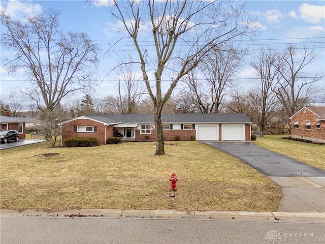 ranch-style house featuring a garage, brick siding, a front lawn, and aphalt driveway