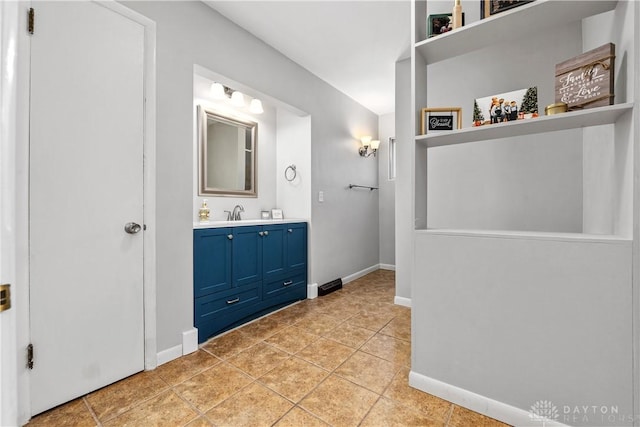 bathroom with vanity, baseboards, and tile patterned floors