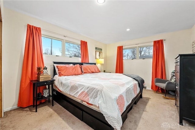 bedroom with baseboards, multiple windows, recessed lighting, and light colored carpet