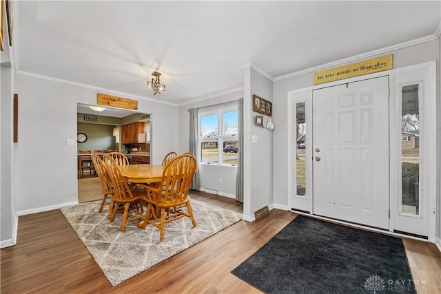 dining area with crown molding, baseboards, and wood finished floors