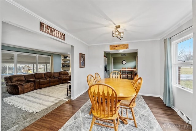 dining room featuring dark wood-style floors, baseboards, a baseboard radiator, and crown molding