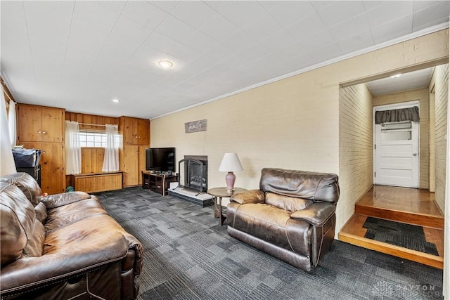 living area featuring dark colored carpet and crown molding