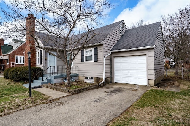 view of front facade featuring a garage, roof with shingles, and aphalt driveway