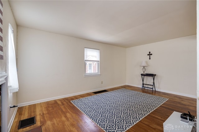 spare room featuring visible vents, baseboards, and wood finished floors