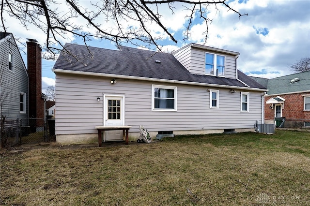 rear view of property with a yard, central AC unit, roof with shingles, and fence