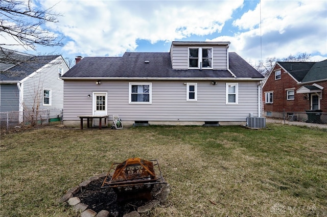 back of house with a fire pit, a lawn, a fenced backyard, and central air condition unit