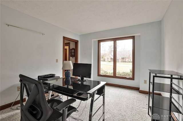 home office featuring baseboards, a textured ceiling, and light colored carpet