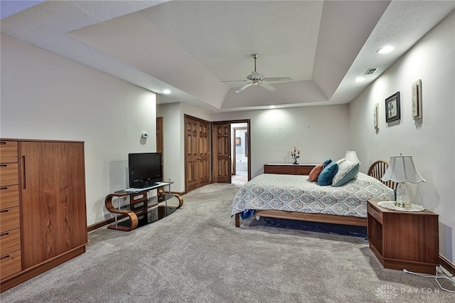 carpeted bedroom featuring a ceiling fan, a tray ceiling, baseboards, and recessed lighting