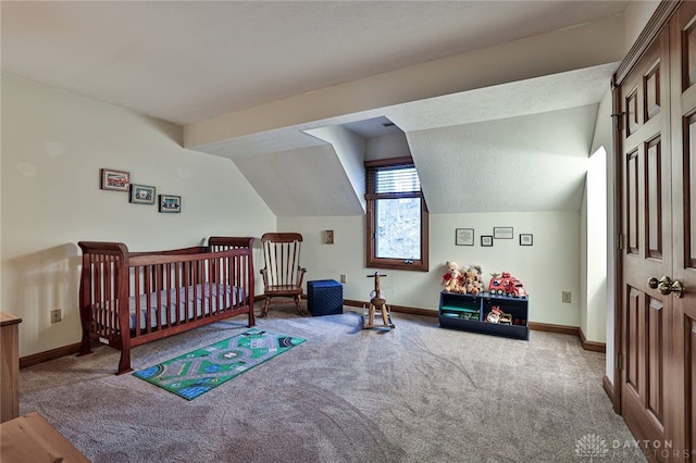 carpeted bedroom with lofted ceiling, a textured ceiling, and baseboards