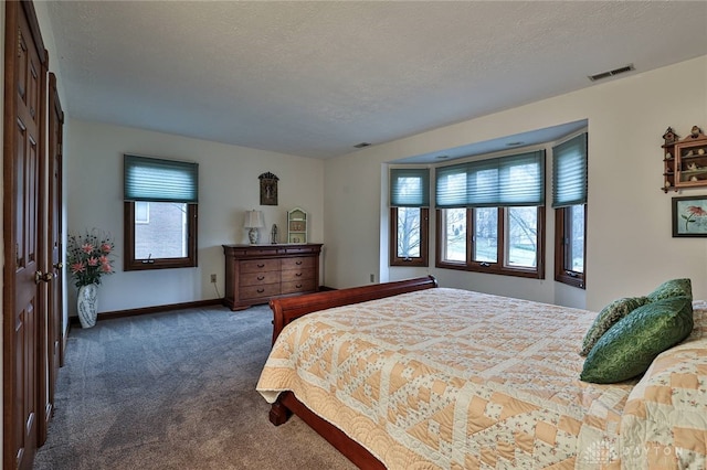 carpeted bedroom featuring baseboards, visible vents, and a textured ceiling