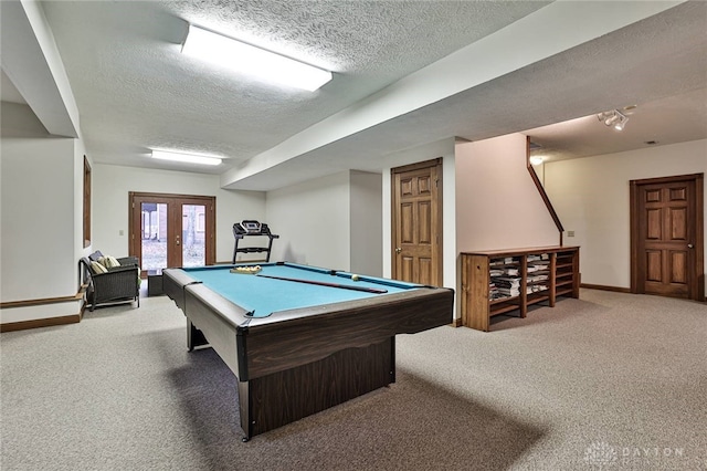 recreation room featuring a textured ceiling, pool table, french doors, and carpet