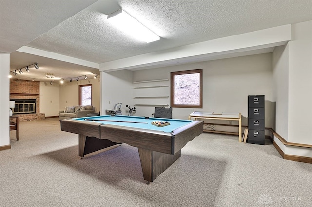 recreation room with light carpet, a fireplace, a textured ceiling, and billiards