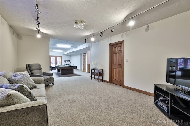 carpeted living area featuring a textured ceiling, french doors, and baseboards