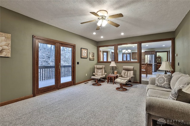 living area featuring recessed lighting, light colored carpet, a textured ceiling, baseboards, and ceiling fan with notable chandelier