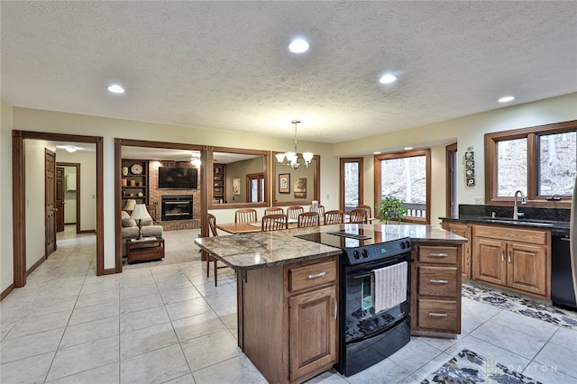 439 Claxton Glen Ct, Dayton, OH 45429 - kitchen featuring black appliances, a sink, a brick fireplace, a textured ceiling, and a kitchen island