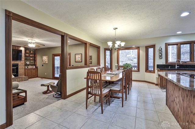 dining space featuring a brick fireplace, light tile patterned floors, built in features, and a textured ceiling