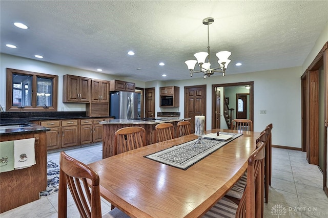 dining space featuring a notable chandelier, light tile patterned floors, recessed lighting, a textured ceiling, and baseboards