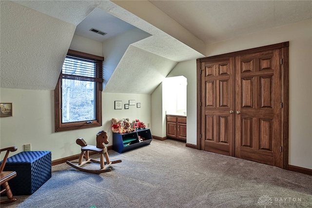 bonus room featuring lofted ceiling, carpet flooring, and a textured ceiling