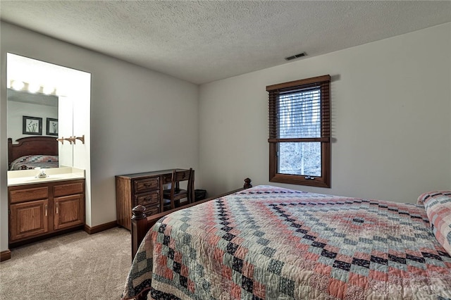 bedroom featuring visible vents, light colored carpet, a textured ceiling, and baseboards