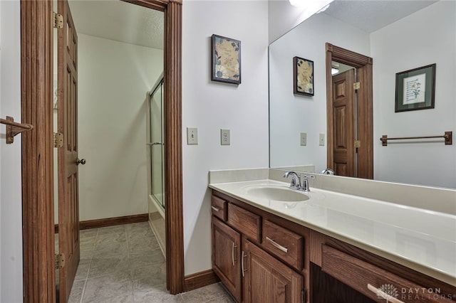 full bath featuring vanity, baseboards, and an enclosed shower