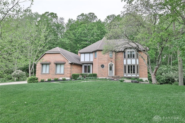 439 Claxton Glen Ct, Dayton, OH 45429 - tudor house featuring a front yard, brick siding, and roof with shingles