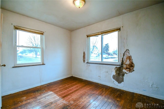 empty room featuring hardwood / wood-style flooring and baseboards