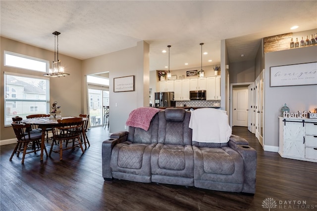 living room featuring baseboards, dark wood finished floors, a notable chandelier, and recessed lighting