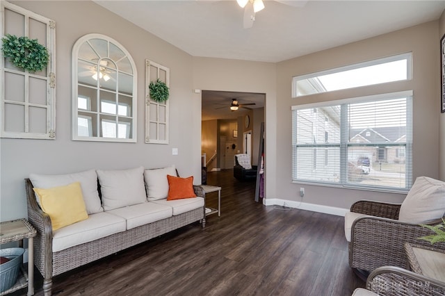 living area featuring dark wood finished floors, stairway, baseboards, and ceiling fan