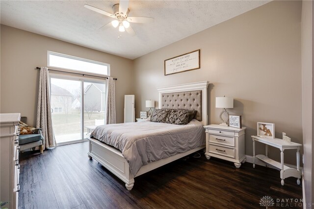 bedroom with a textured ceiling, dark wood-type flooring, a ceiling fan, and access to exterior