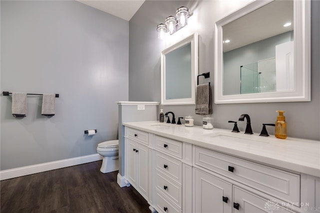 bathroom featuring toilet, a shower, a sink, and wood finished floors