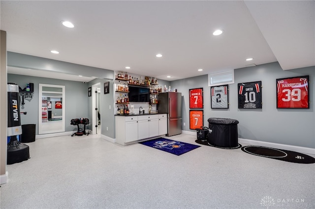 interior space with baseboards, bar area, freestanding refrigerator, and recessed lighting