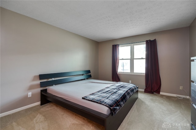 bedroom featuring carpet flooring, a textured ceiling, and baseboards