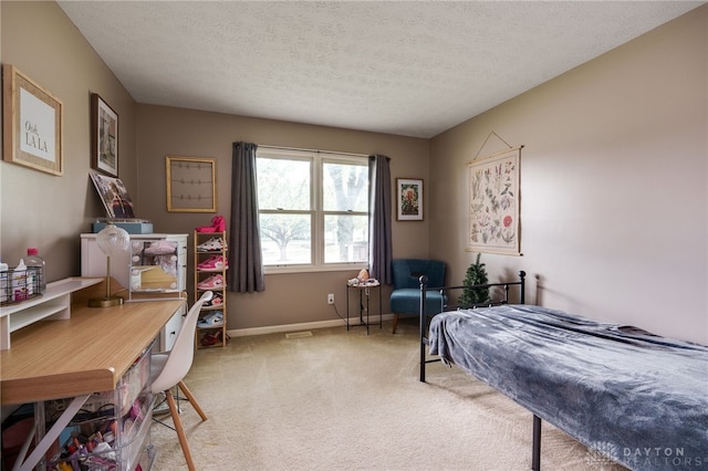 bedroom with a textured ceiling, carpet, and baseboards