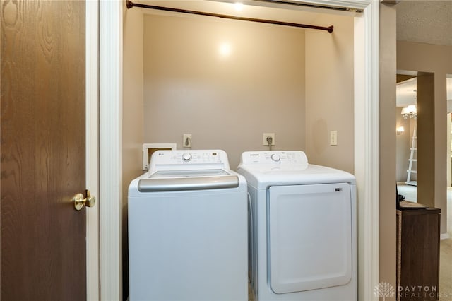 washroom featuring a textured ceiling, laundry area, and washer and clothes dryer