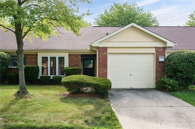 single story home featuring a garage, driveway, a front lawn, and brick siding