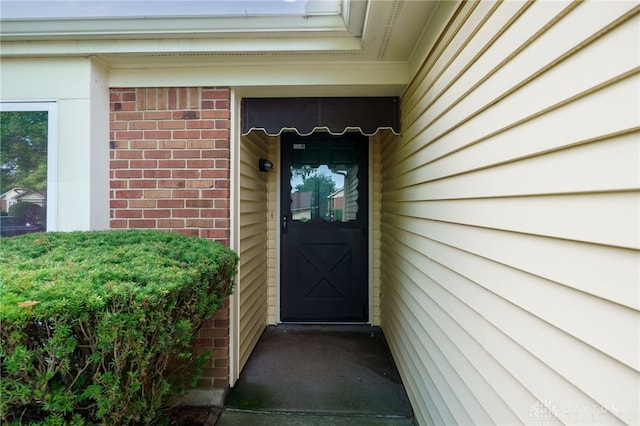 property entrance featuring brick siding