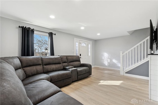 living area with baseboards, stairway, recessed lighting, and light wood-style floors