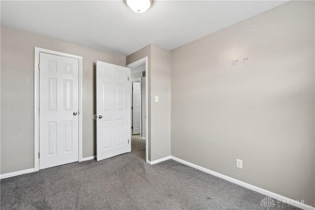 unfurnished bedroom featuring carpet floors and baseboards