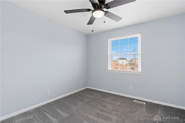 unfurnished room featuring dark colored carpet, visible vents, ceiling fan, and baseboards