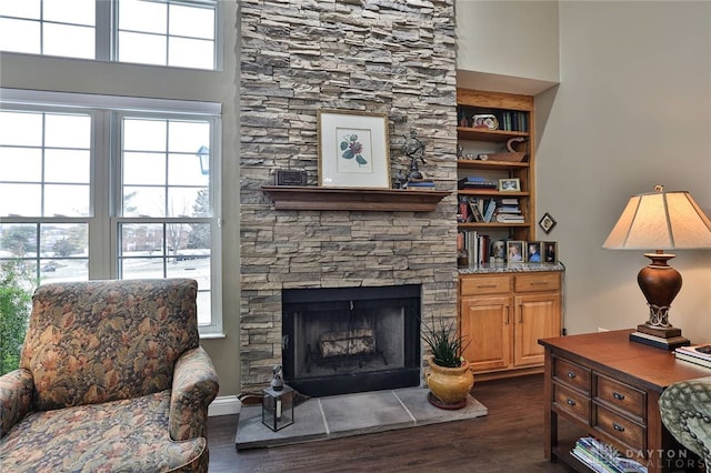 sitting room with dark wood-style floors, plenty of natural light, and a fireplace