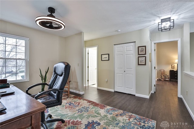 home office featuring a textured ceiling, dark wood-style flooring, and baseboards