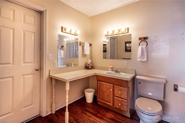 bathroom featuring toilet, wood finished floors, and vanity