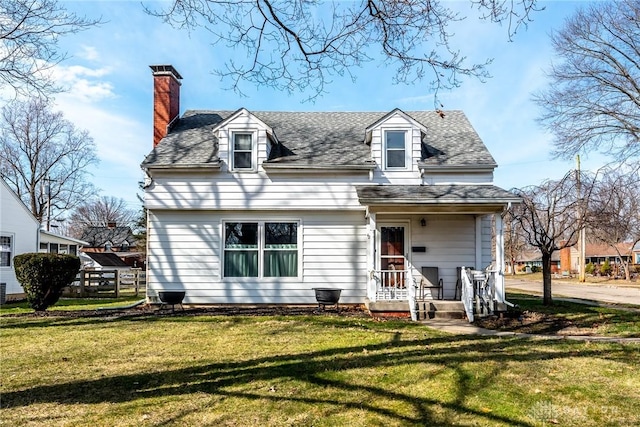 back of house featuring a shingled roof, a lawn, and a chimney